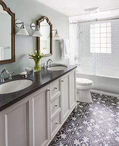 a bathroom with two sinks, a toilet and a bathtub