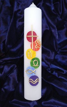 a white candle with seven chakras on it and the word omen spelled in gold