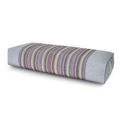 a large pillow with multicolored stripes on the front and back side, sitting on a white surface