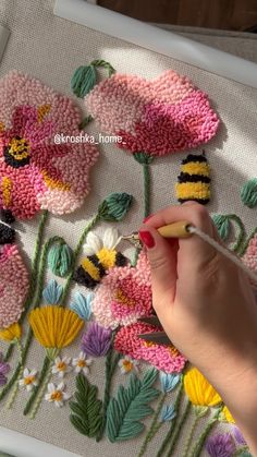 a woman is working on some flowers with crochet and yarn in the shape of bees