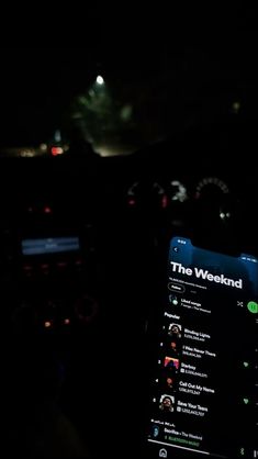 the dashboard of a car at night with lights in the background and an app on it