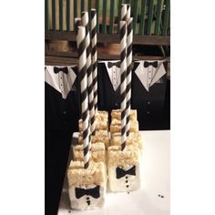 two black and white striped straws are stacked on top of rice krispy treats