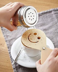 a person pouring coffee into a cup with a smiley face on it