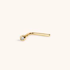 Our dainty Tiny Diamond nose stud in 14k gold gives you the perfect amount of shine for everyday - think of it as our nose stud version of our signature Tiny Crystal Studs. A diamond nose stud is the perfect piece to add a bit of an edge to your look in brilliant, beautiful solid 14k gold. Our diamond nose stud is safe for sensitive skin and healing piercings. Specs & Sizing Solid 14k gold nose stud White diamond in 2mm bezel 6.5mm post, 6mm after the bend, 20g wire (0.8MM) Elegant Everyday Yellow Gold Nose Studs, Elegant Yellow Gold Nose Studs, Classic 14k Yellow Gold Nose Studs, Elegant Tiny Yellow Gold Nose Studs, Minimalist 14k Yellow Gold Nose Rings, Elegant 14k Yellow Gold Nose Rings, Healing Piercings, L Shaped Nose Ring, Diamond Nose Stud