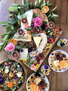 a table topped with lots of different types of food next to bowls filled with fruit and veggies