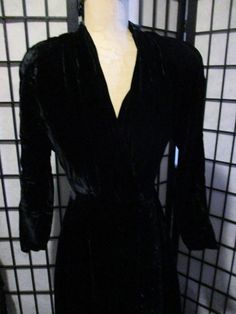 Here is a fantastic black velveteen hostess gown or lounge dress from the 1940's/50s. Lounging around in the pj's is fine if you are by yourself. This is what you wear when company comes over. Get out the martini glasses. It has a front opening that hooks at the waist. The neckline is a deep vee. The sleeves are raglan and the skirt flares. Long sleeved. Fantastic condition. The shoulders are well padded. Measurements in inches: neck to end of sleeve: 28 length to waist: 18 length of skirt: 30 b Fitted Long Evening Robe, Fitted Long Sleeve Evening Robe, Formal Fitted Long Sleeve Robe, Black Velvet V-neck Dress For Night Out, Black V-neck Velvet Dress, Fitted Formal Robe For Fall, Velvet Long Sleeve Dress For Costume Party, Long Sleeve Velvet Dress For Costume Party, Black Long Evening Robe