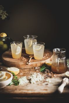 three glasses filled with lemonade on top of a wooden table