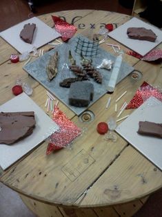 a wooden table topped with lots of different types of cakes and desserts on top of it