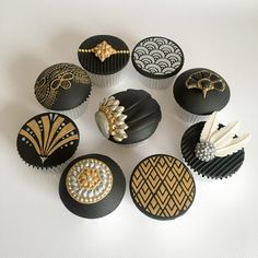 nine cupcakes decorated with black and gold designs