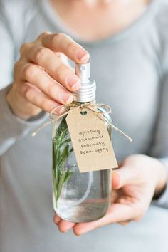 a person holding a bottle with some plants in it and a tag attached to the bottle