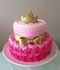 a pink and gold cake with a crown on top