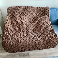 a large brown blanket sitting on top of a blue couch