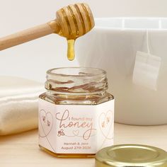 a jar of honey with a wooden spoon next to it