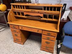 an old wooden desk with two chairs next to it in a room filled with furniture