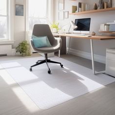 an office with a chair, desk and computer on the floor in front of a window