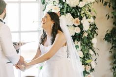 a bride and groom holding hands during their wedding ceremony