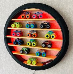 there are many toy cars on the shelf in the wall mounted to the round frame