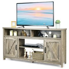 a flat screen tv sitting on top of a wooden entertainment center