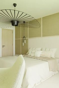 a large bed sitting under a light fixture in a bedroom