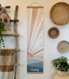 a room with some plants and baskets on the wall next to a ruler that says lucky