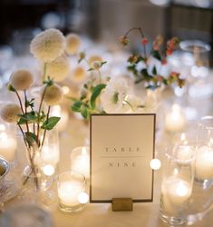 the table is set with candles, flowers and place cards for guests to write their names