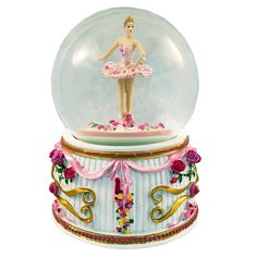 a snow globe with a ballerina figure in it's center and roses on the bottom