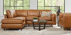 a living room with brown leather furniture and large windows