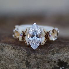 a close up of a ring with a diamond on it's center and two shells around the band