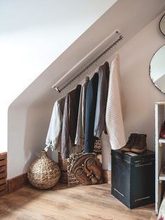 a room with clothes hanging on the wall and other items sitting on top of it