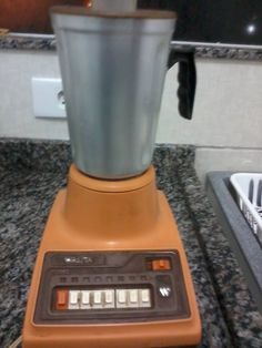 an orange blender sitting on top of a counter