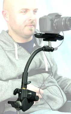 a man sitting in front of a camera holding a cell phone up to his face