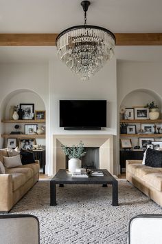 a living room filled with furniture and a flat screen tv mounted on the wall above a fireplace