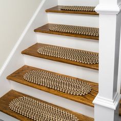 a set of wooden stairs with braided rugs on them