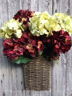 a basket filled with flowers sitting on top of a wooden fence