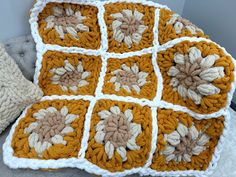 a crocheted granny blanket is sitting on a couch