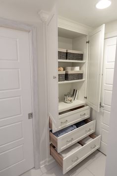 an open white closet with drawers and shelves