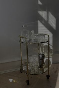 a glass serving cart with glasses on it