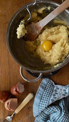 an image of mashed potatoes and eggs in a pan on the table with utensils