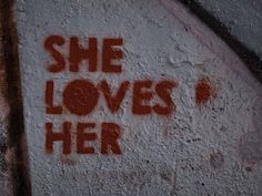 graffiti on the side of a building that says she loves her with red spray paint