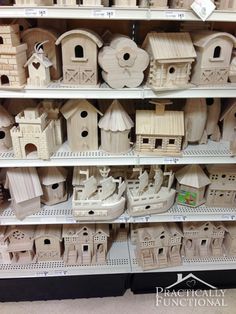 many wooden houses are on shelves in a store