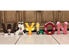 the letters are made out of wood and have farm animals on them