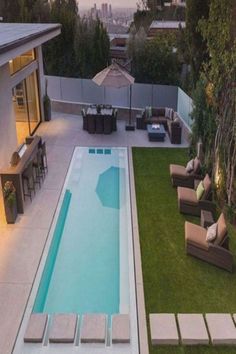 an aerial view of a backyard with a swimming pool and lounge chairs in the foreground