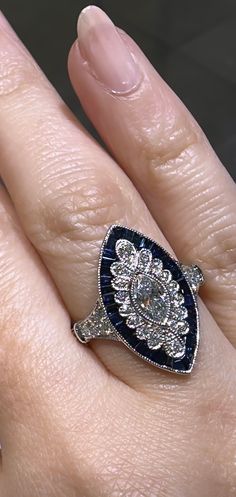 This sophisticated 1.90ct tw marquise shape sapphire and diamond art-deco style ring is sure to make a lasting statement. Crafted with luxurious sapphires and dazzling diamonds, this piece exudes luxurious elegance and timeless sophistication! Metal: 18K White GoldDiamond Shape: Brilliant Round Cut & Baguette CutDiamond Weight: 36 Round cut 0.38ct tw Sapphire: 37 Baguette-cuts 1.11ct twCenter Diamond Details: 1 Marquise cut 0.41carat For desired ring size please leave us a note at the check out. Baguette Cut, Marquise Cut, Diamond Art, Deco Style, Art Deco Fashion, Round Cut, Sapphire, Ring Size, Art Deco