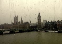 the big ben clock tower towering over the city of london from across the river thames