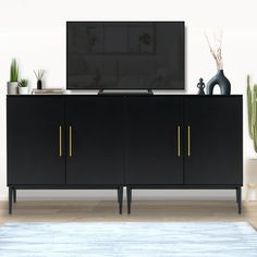 a flat screen tv sitting on top of a black cabinet