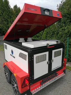 a red and white trailer with an open top on the back in a parking lot