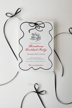 a white and black wedding card with a bow on the front is surrounded by ribbon