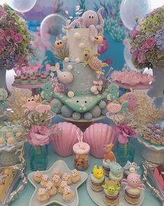 a table topped with lots of cakes and cupcakes