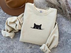 Halloween Embroidered Sweatshirt, Halloween Cat Shirt, Black Cat Shirt, Spooky Cat, Cute Halloween Sweatshirt, Cute Cat Sweater, Cat Lover Cozy Up with Our Embroidered Black Cat Fall Sweatshirt! Embrace the charm of autumn with our adorable and cozy sweatshirt. Perfect for cat lovers and fall enthusiasts alike! Charming Design: Cute embroidered black cat Comfy and Durable: Soft cotton-polyester blend Perfect Fit: Available in multiple sizes Warm and Cozy: Ideal for cool fall days -------- This e Trendy Fall Tops With Cat Design, Casual Halloween Sweatshirt With Cat Design, Casual Halloween Sweatshirt With Cat Print, Cotton Cat Design Tops For Fall, Cotton Cat Design Top For Fall, Cotton Tops With Cat Design For Fall, Cotton Top With Cat Design For Fall, Trendy Fall Sweatshirt With Cat Design, Fall Sewing Projects