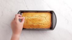 a person placing a loaf of bread in a pan